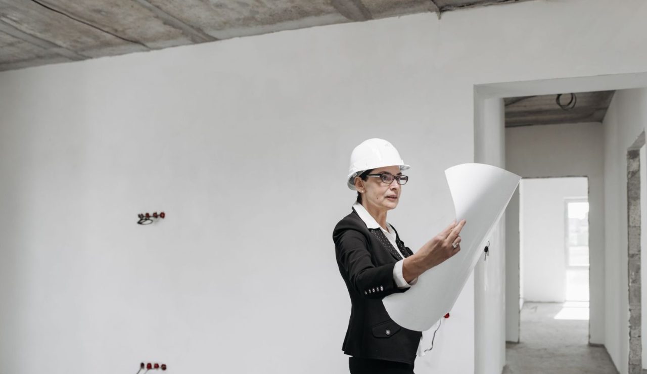 Architecte examinant des plans de construction dans un espace de travail lumineux