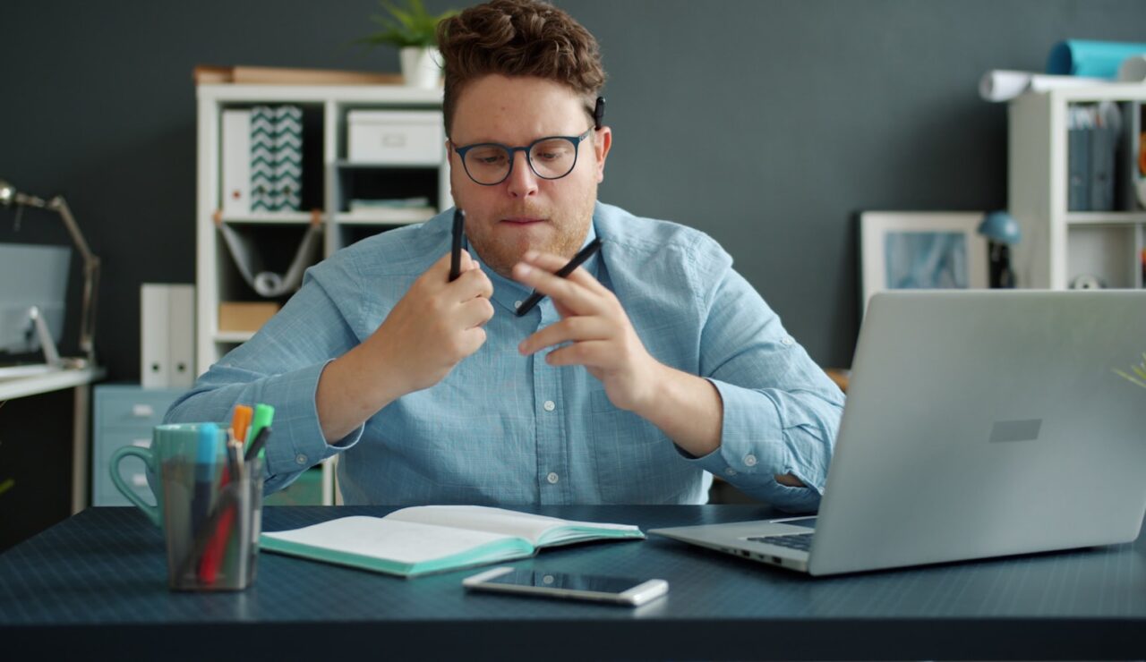 Un candidat installé à son bureau prépare ses réponses face à la caméra de son ordinateur portable
