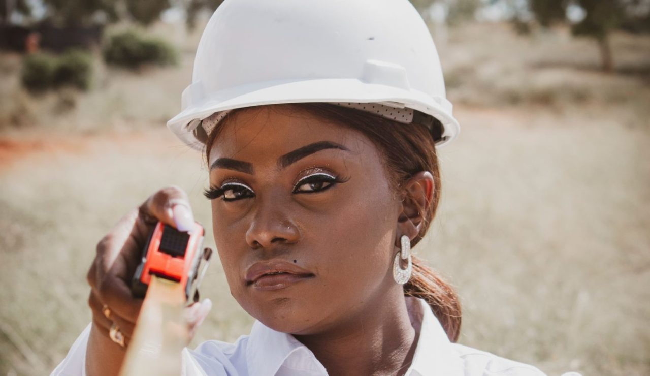 Ingénieure en équipement de sécurité tenant un mètre ruban sur un chantier en extérieur