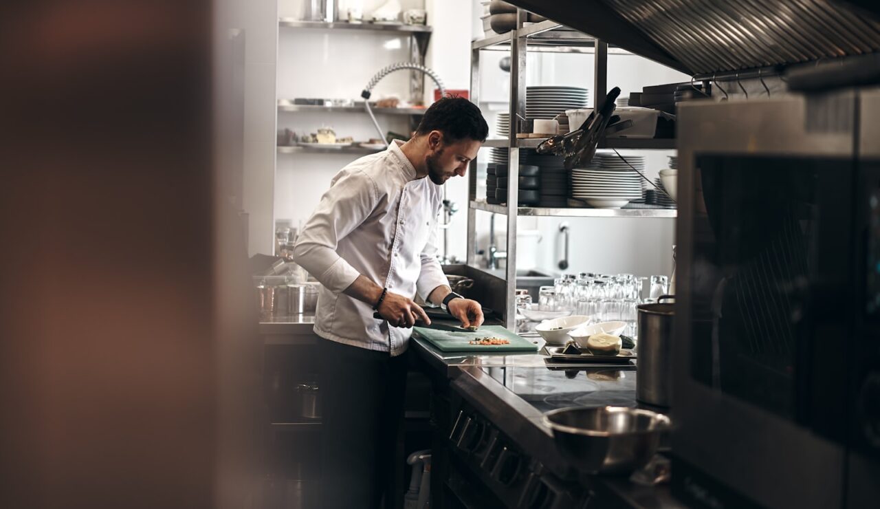 Un cuisinier prépare un plat dans la cuisine d’un restaurant, l’un des métiers qui recrutent le plus selon France Travail