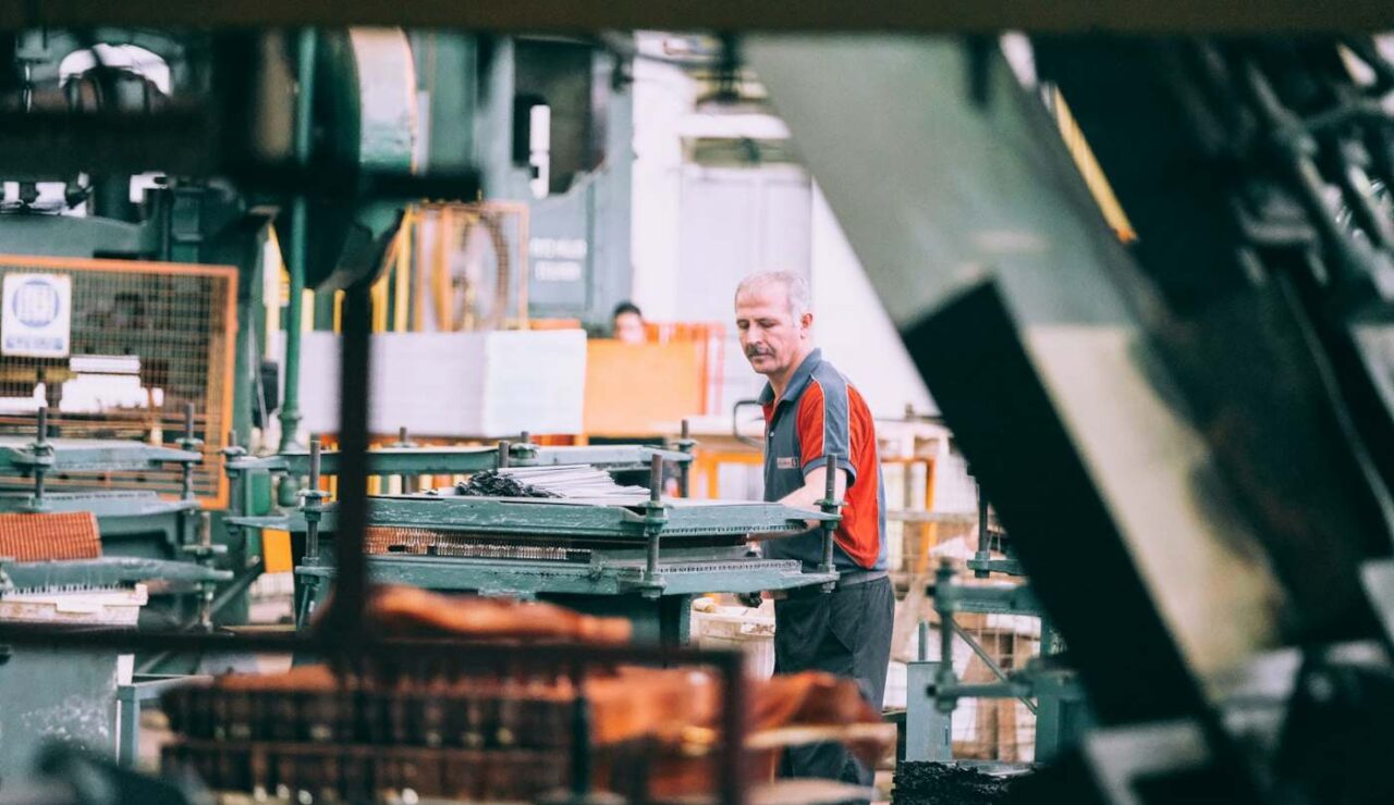 Ouvrier au travail sur une machine dans un atelier industriel en fin de journée